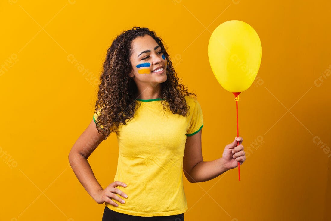 Mulher com pintura facial segurando balão amarelo