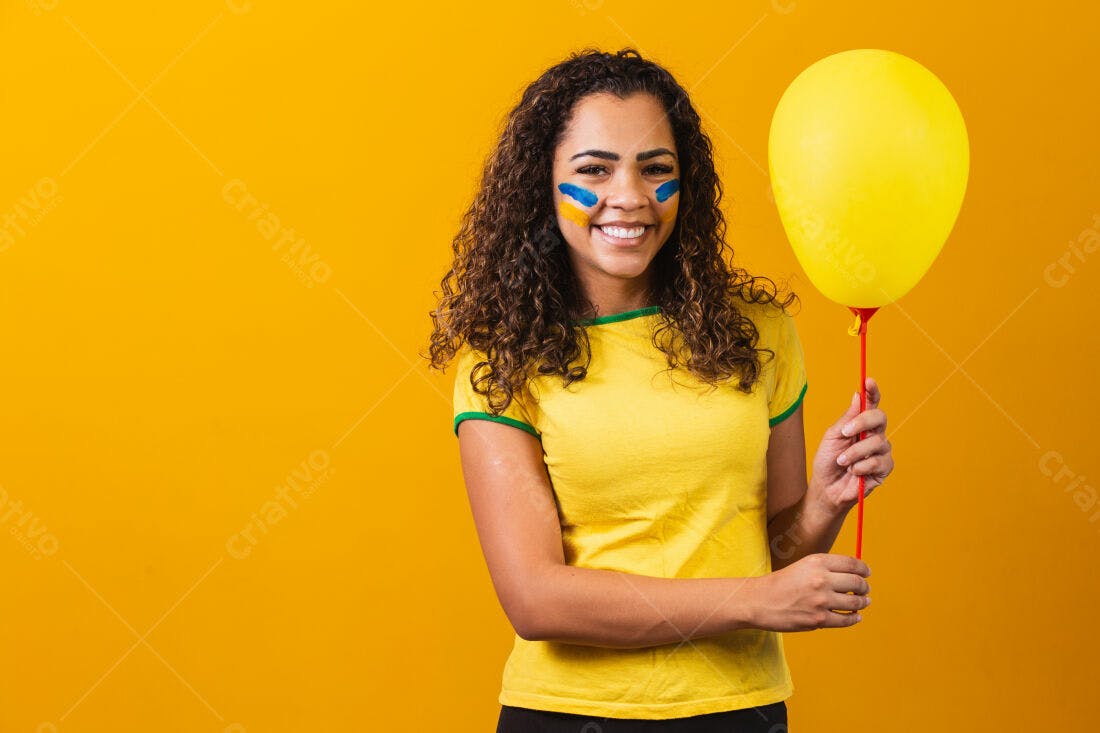 Mulher sorridente com pintura facial e balão amarelo