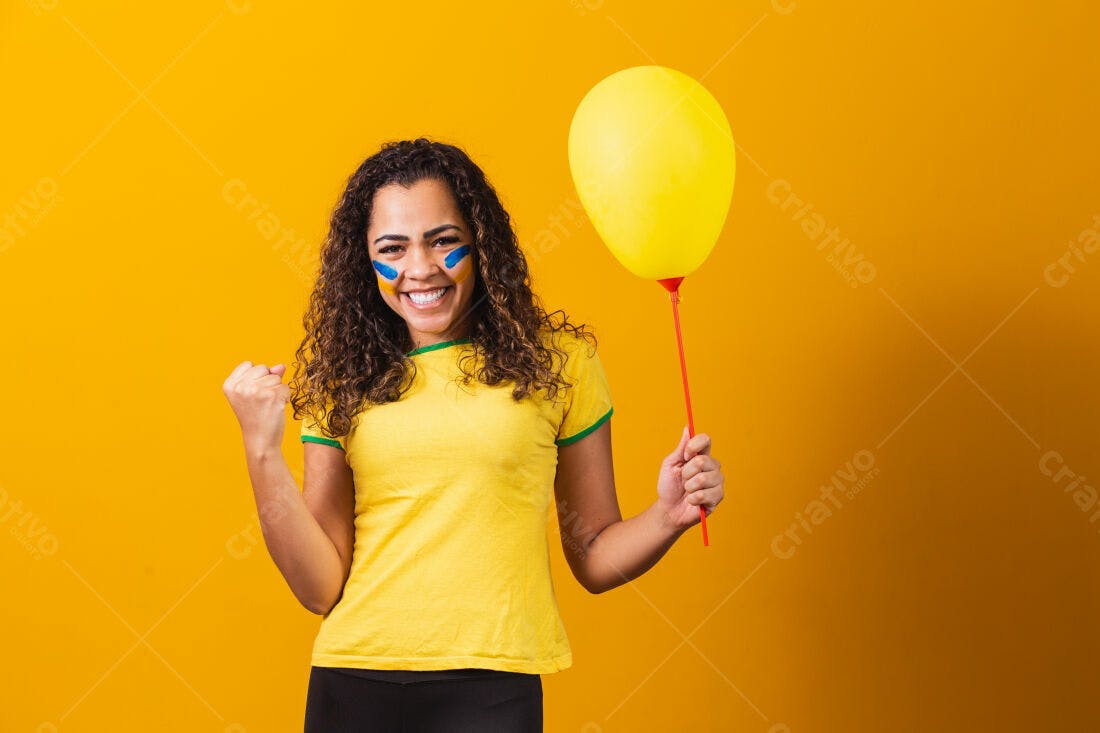 Torcedora brasileira eufórica com balão amarelo