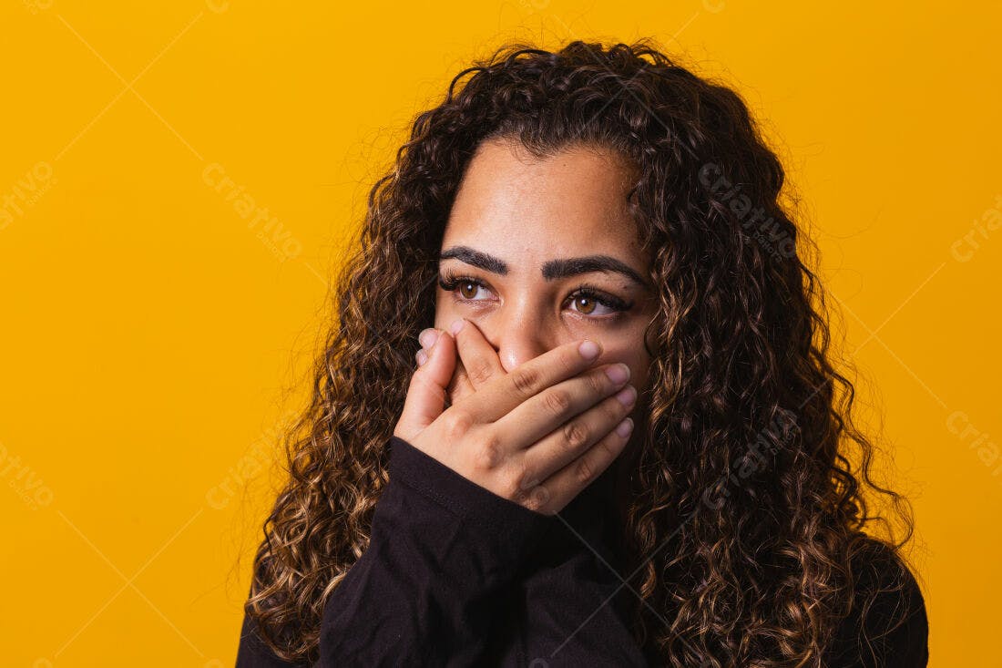 Mulher com cabelo cacheado cobrindo a boca