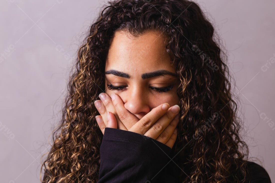 Mulher com cabelo cacheado cobrindo a boca