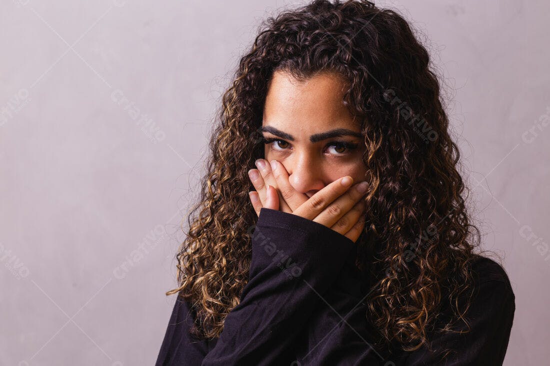Mulher com cabelo cacheado cobrindo a boca