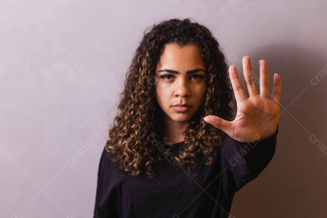 Mulher com cabelo cacheado mostrando a mão