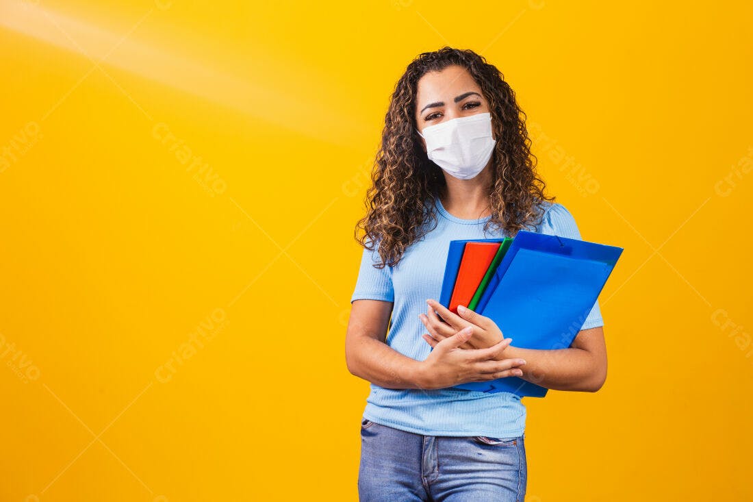 Professora com máscara usando pastas coloridas