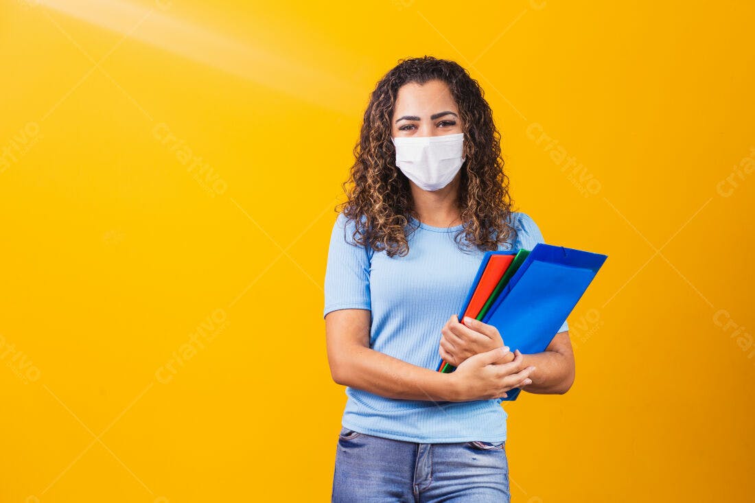 Estudante com máscara usando pastas coloridas fundo amarelo