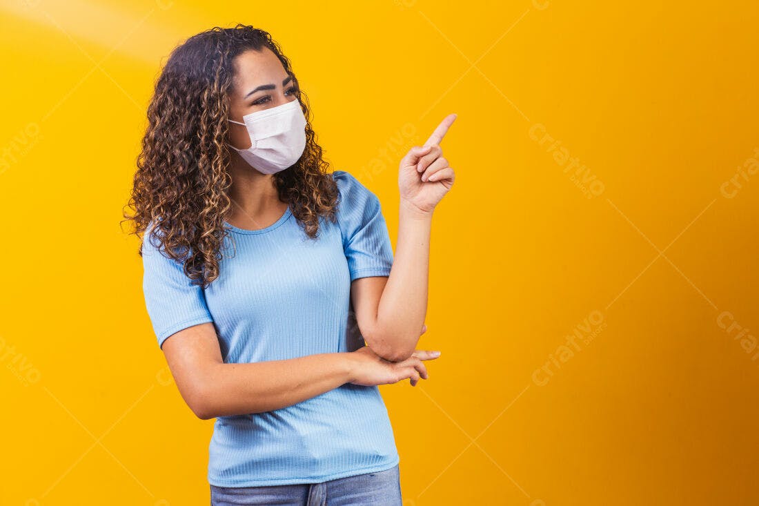 Mulher com máscara apontando fundo amarelo