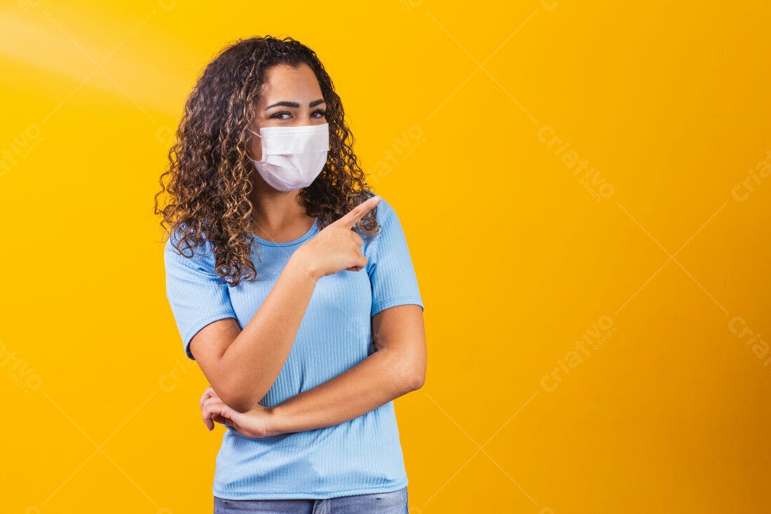 Mulher aponta usando máscara fundo amarelo