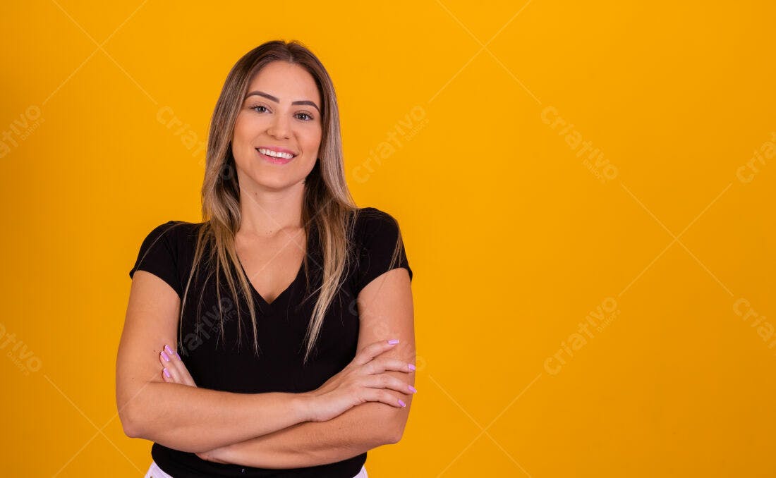 Mulher sorrindo fundo amarelo braços cruzados