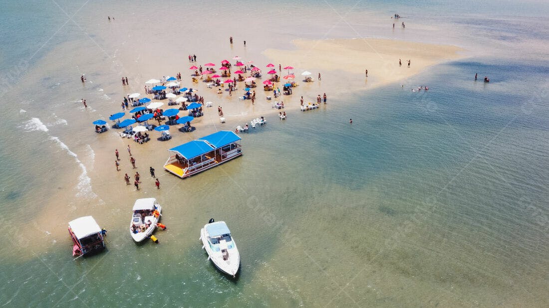 Banco de areia paradisíaco com barcos e guarda-sóis