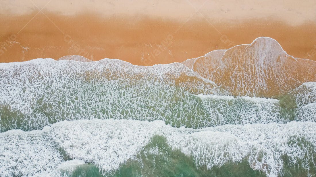 Ondas quebrando na praia arenosa