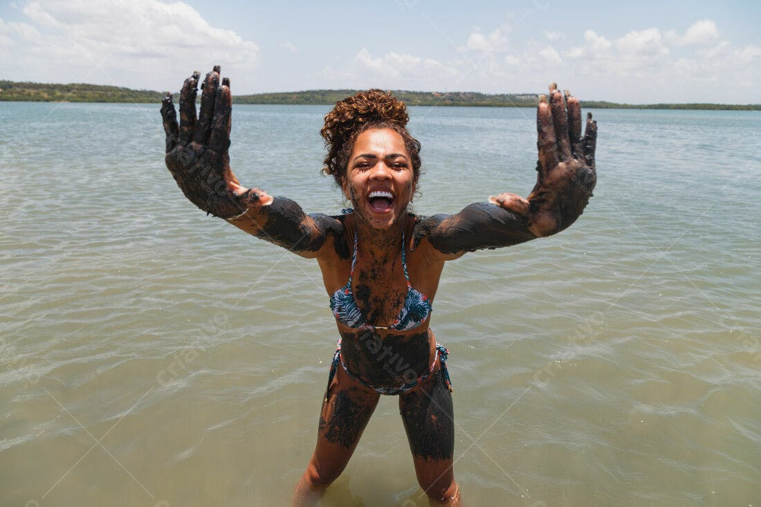 Mulher na lama em praia ensolarada