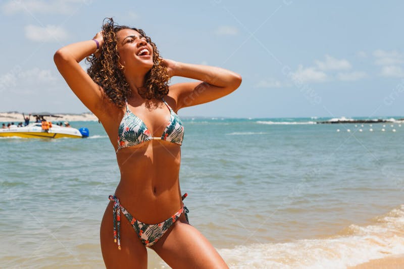 Mulher jovem morena bonita de biquíni fazendo pose na praia
