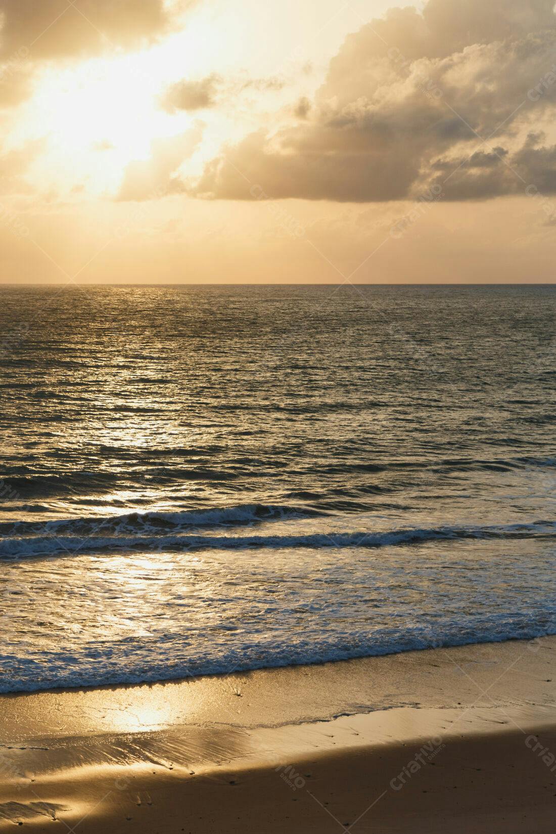 Pôr do sol dourado na praia arenosa