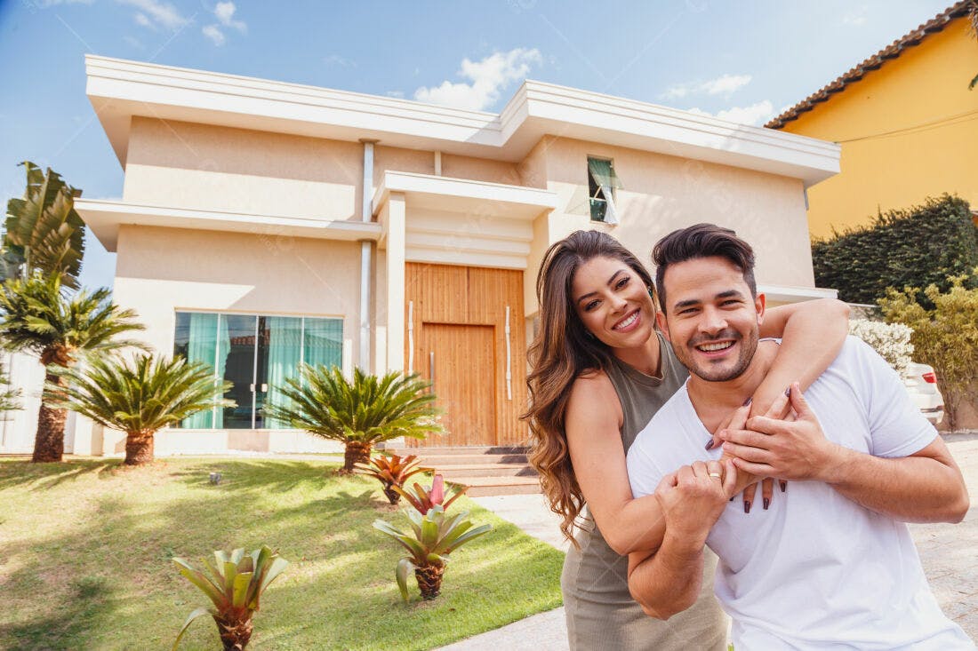 Casal feliz na frente de casa nova