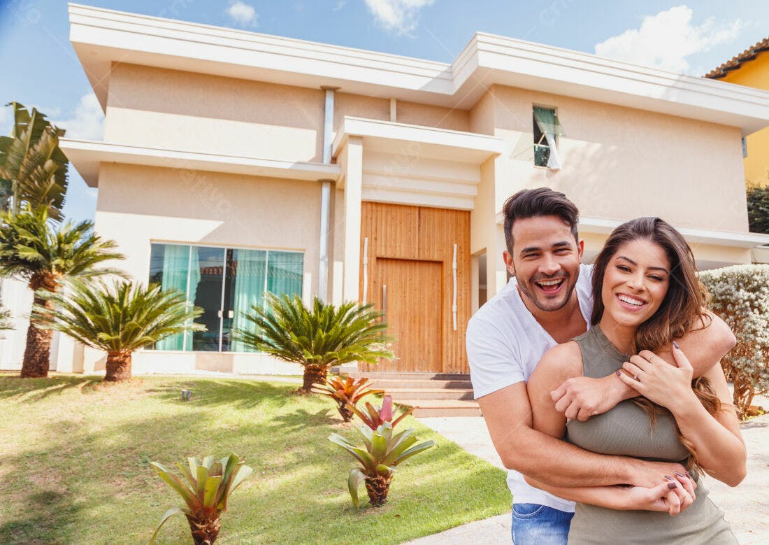 Casal feliz em frente a casa nova