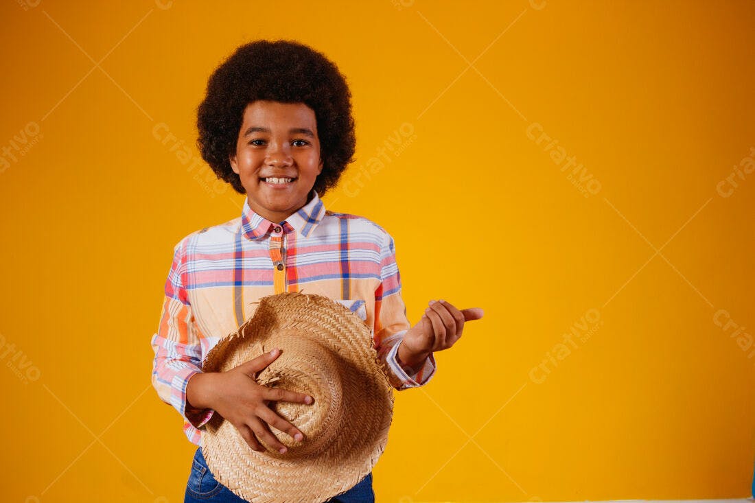 Menino sorridente com chapéu de palha fundo amarelo