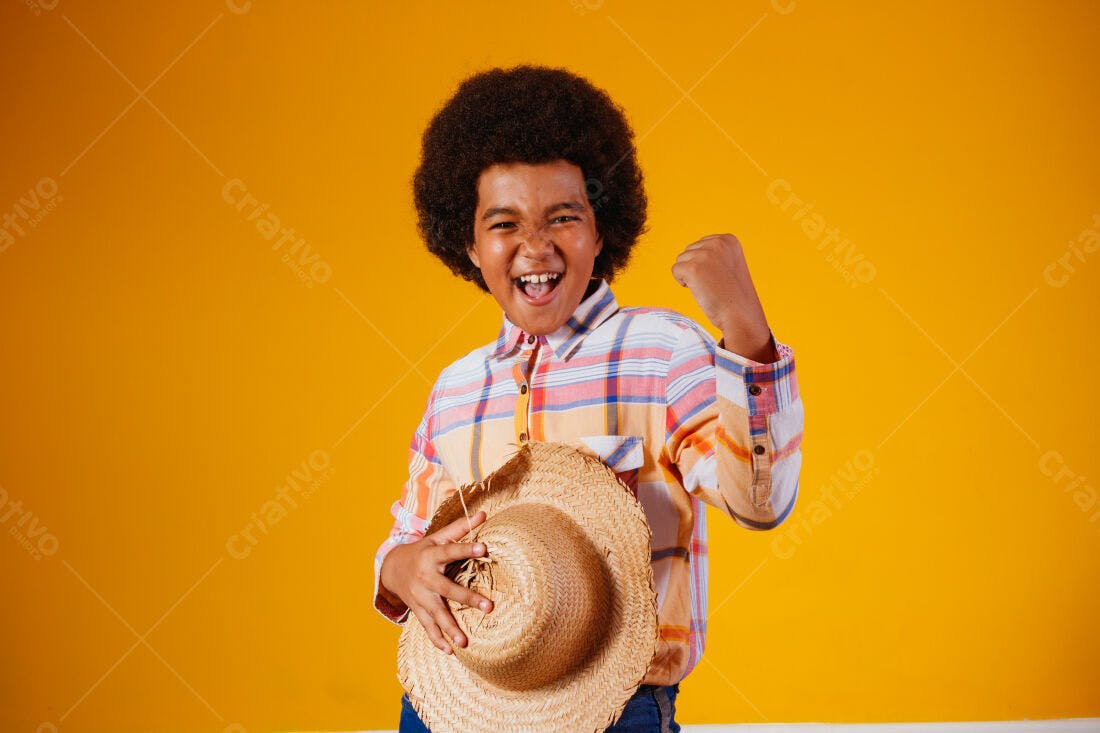 Menino alegre com chapéu de palha fundo amarelo