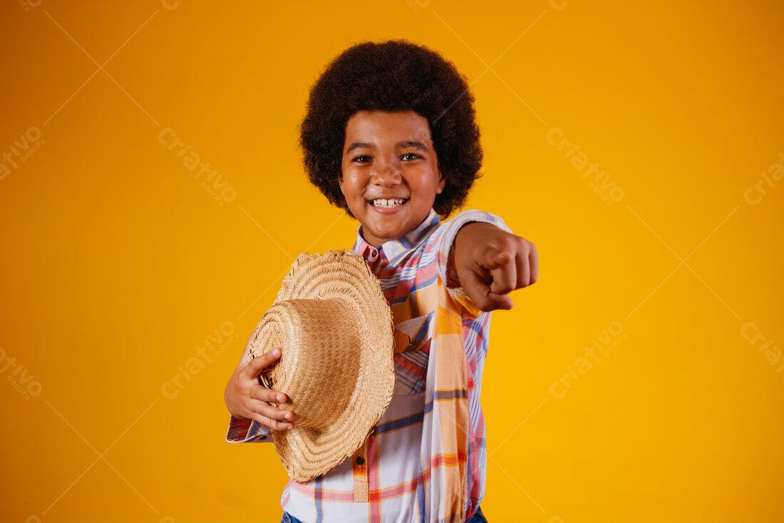 Menino alegre com chapéu de palha fundo amarelo