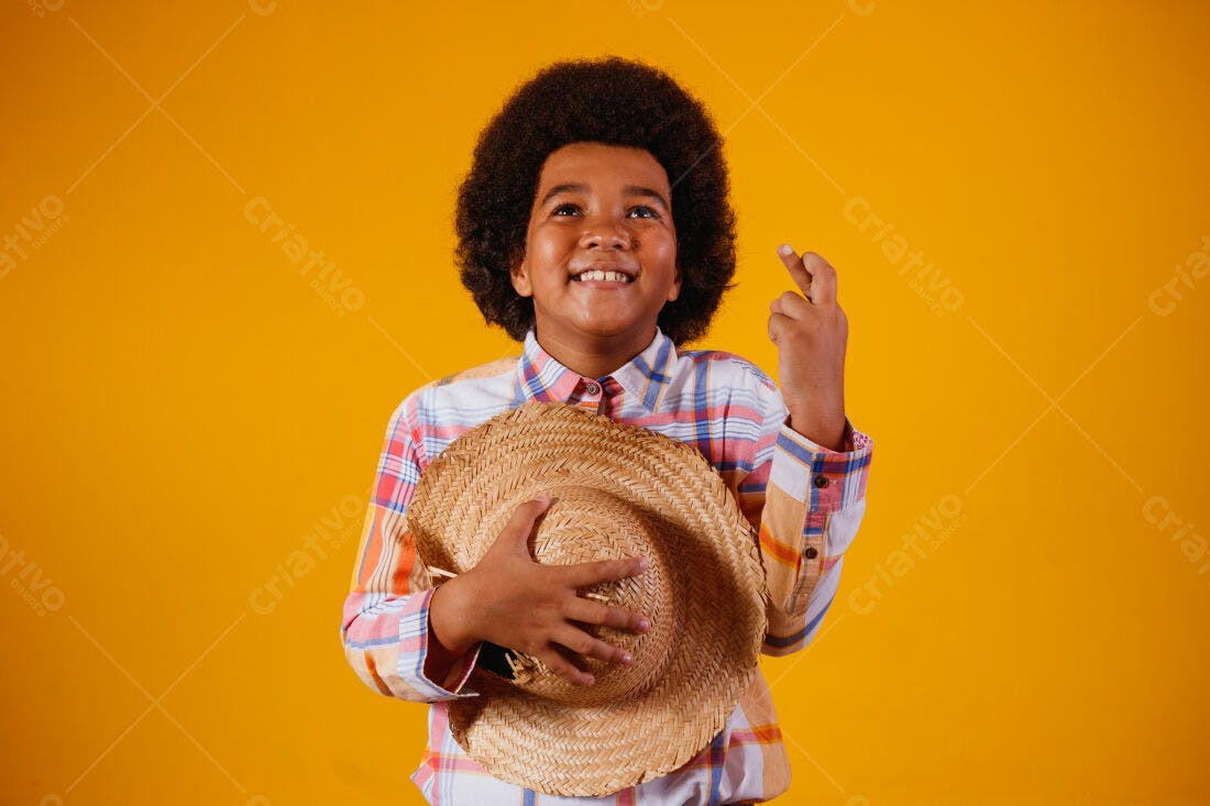 Menino afro com chapéu de palha fundo amarelo