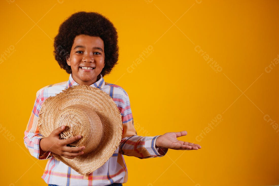 Menino sorridente com chapéu de palha fundo amarelo