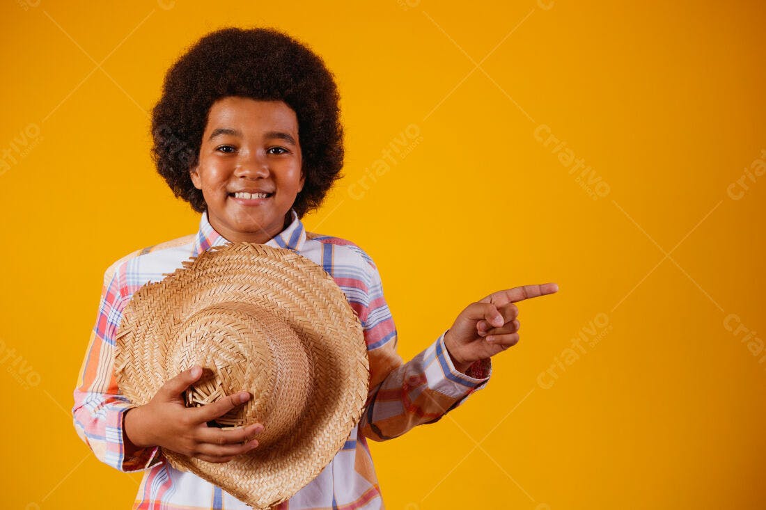 Menino sorridente com chapéu de palha fundo amarelo