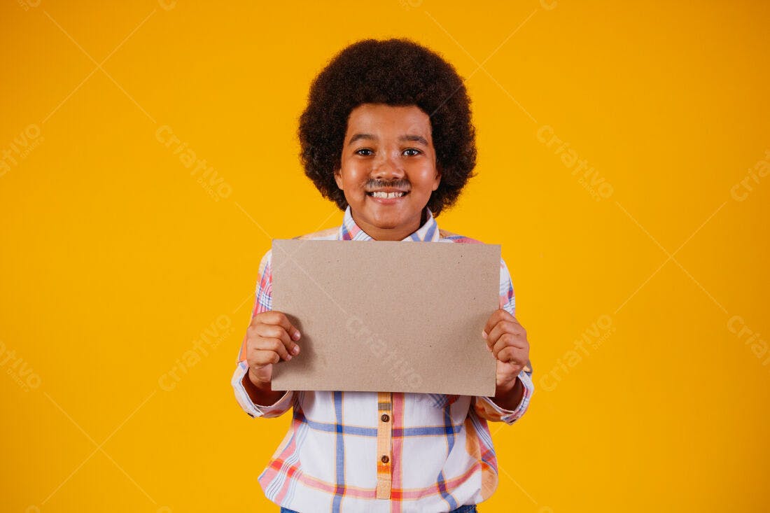 Menino sorridente com cartaz pardo fundo amarelo