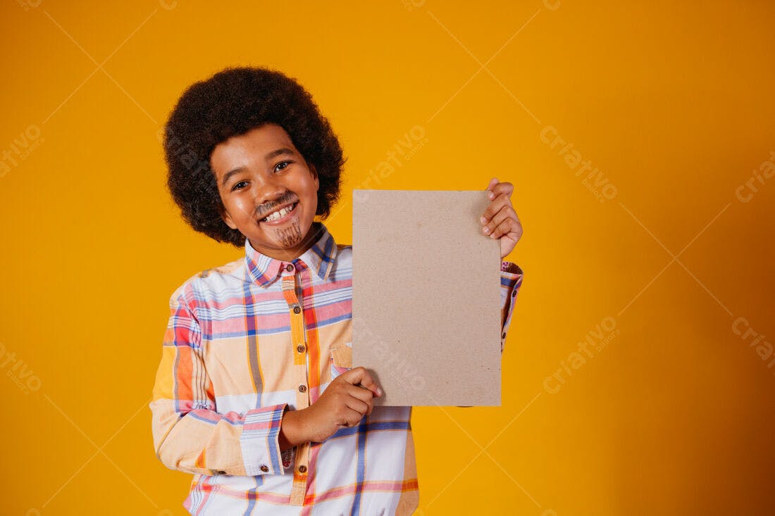 Menino afro sorridente segurando cartaz marrom