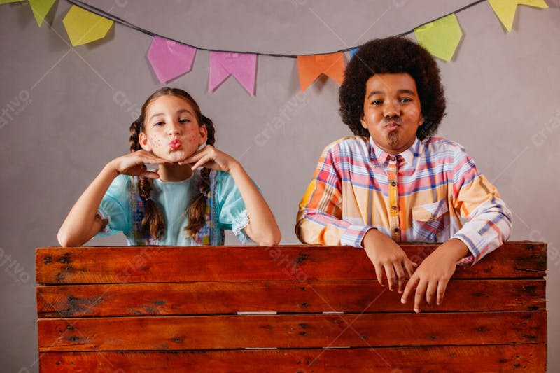 Menino e menina criança na barraca da festa junina julina mandando beijo