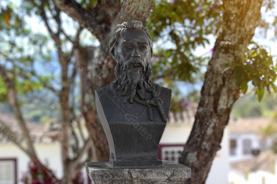 Busto de homem barbudo em parque arborizado