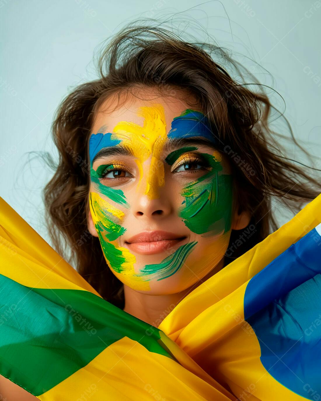 Mulher com pintura facial verde amarela e azul segurando bandeiras brasileiras