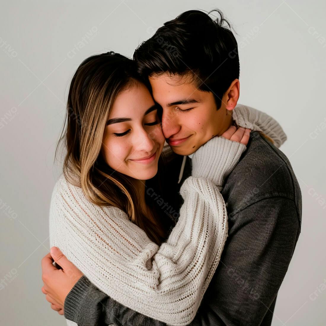 Casal abraçado com suéteres claros e escuros