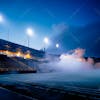 Modernized, smoke filled soccer stadium, illuminated by lights