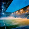 Modernized football stadium filled with smoke and illuminated by lights