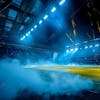 Modernized football stadium full of smoke and illuminated by lights