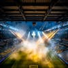 Modernized football stadium filled with smoke and illuminated by lights