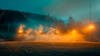 Modernized football stadium filled with smoke and illuminated by lights.