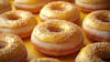 The image displays a variety of donuts with a bright lemon yellow glaze