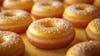 The image features a variety of donuts with a bright lemon yellow glaze.