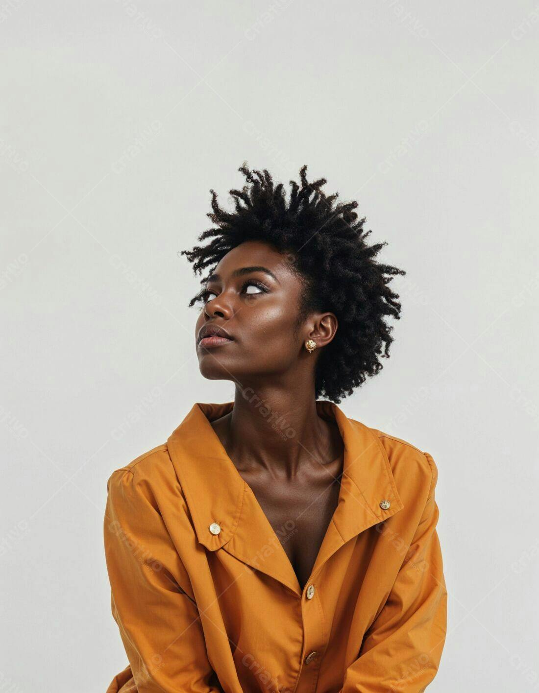 Mulher negra em camisa mostarda olhando para cima