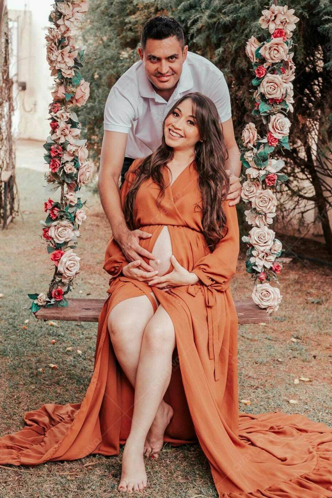Casal grávido em balanço com flores