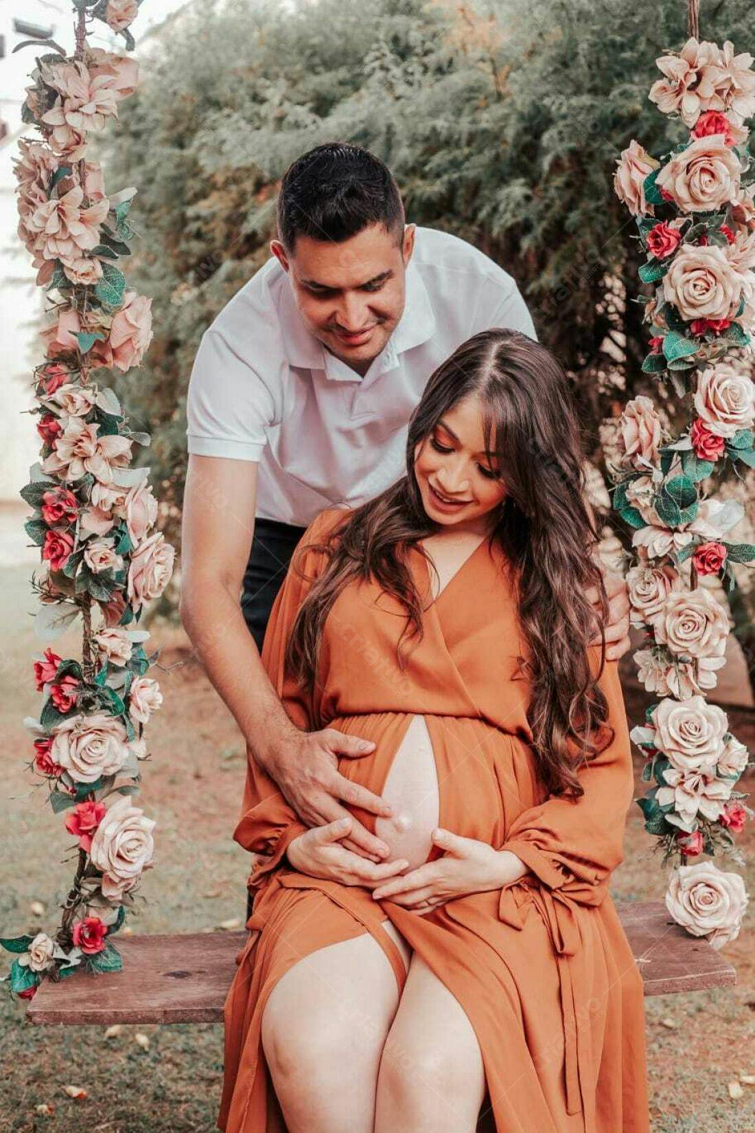Casal grávido em balanço floral