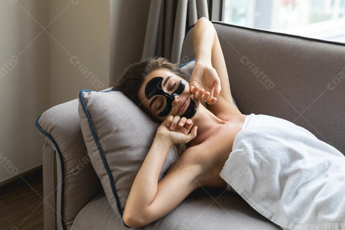 Mulher relaxada com máscara facial em sofá