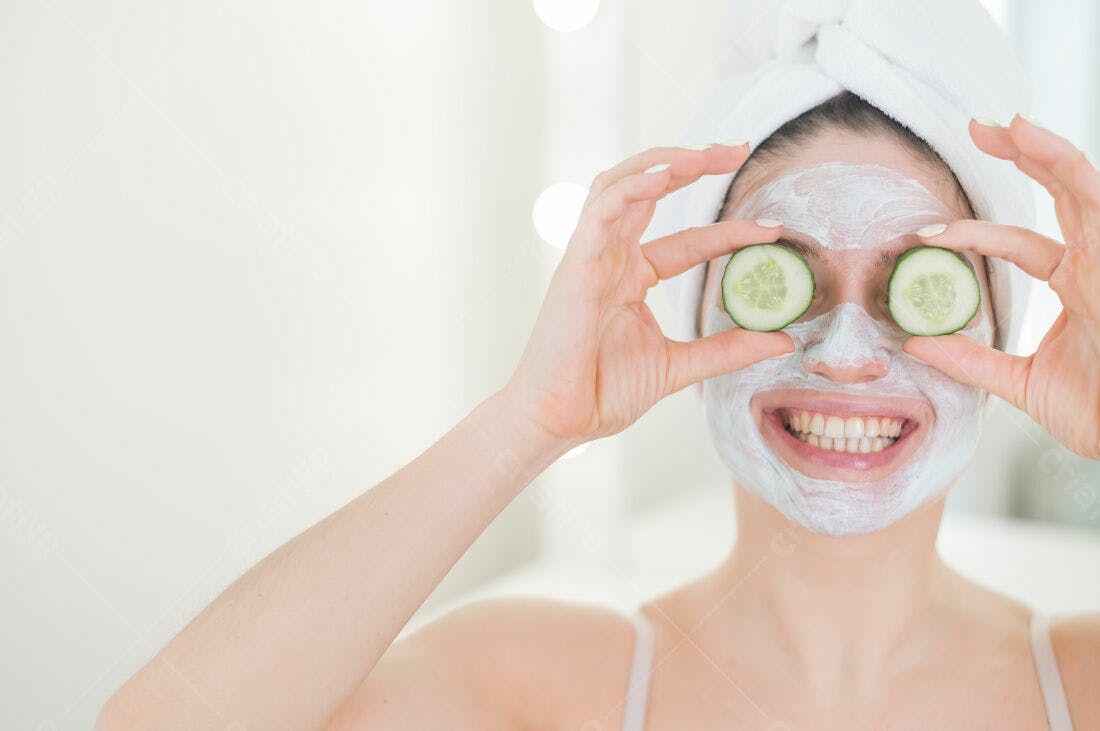 Mulher com máscara facial e pepino nos olhos