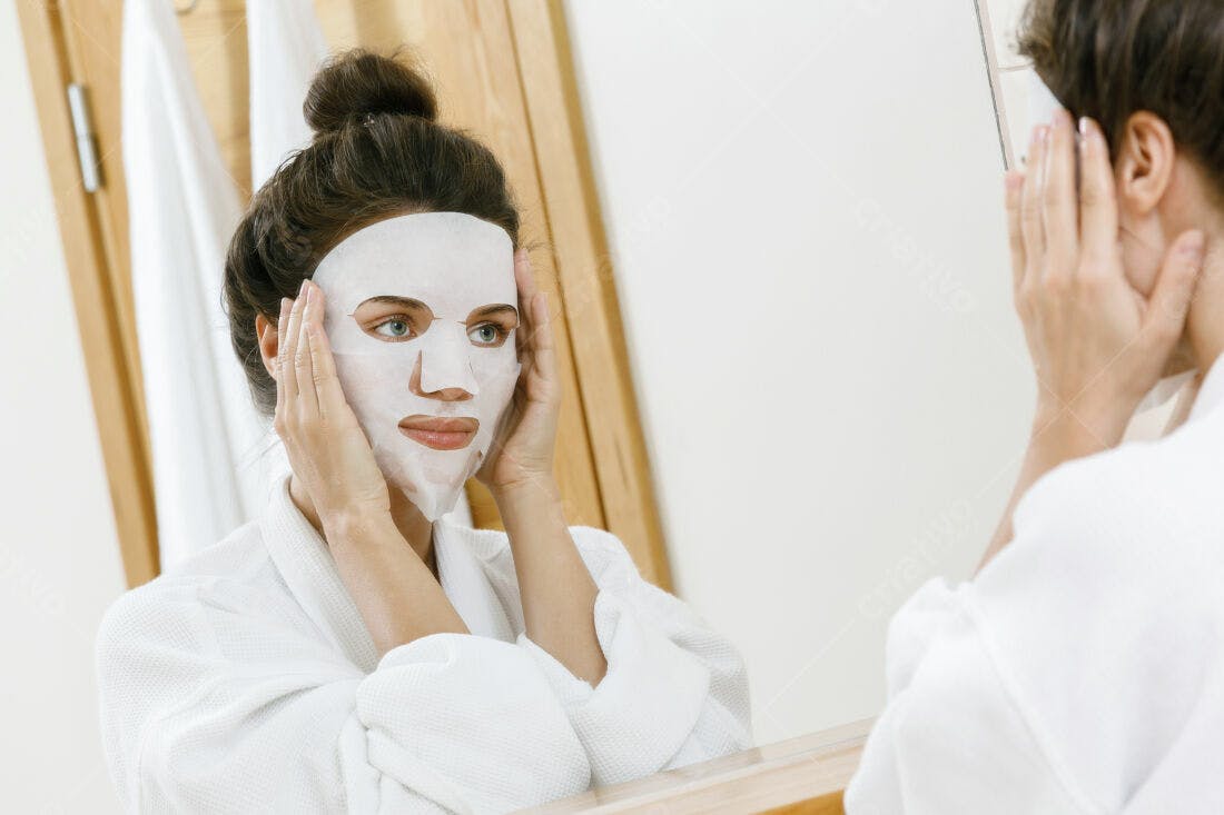 Mulher aplicando máscara facial no espelho