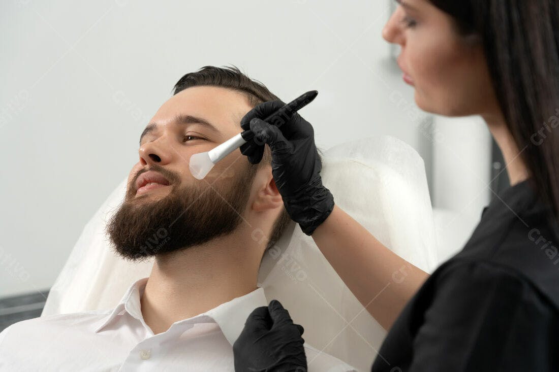 Homem com barba recebendo tratamento facial