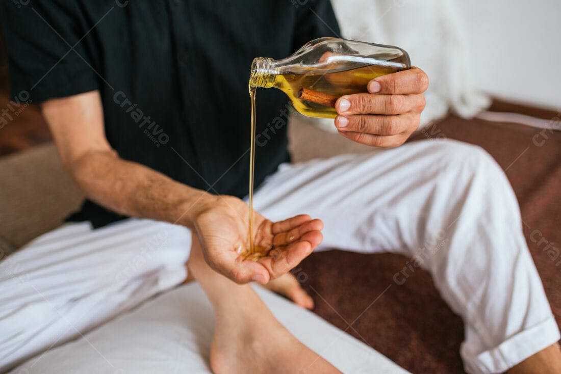 Massagista despejando óleo de canela em suas mãos