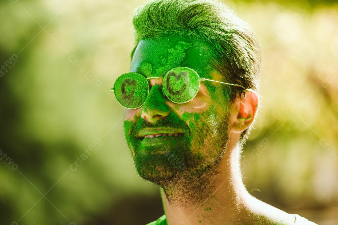 Homem com tinta verde no rosto e óculos redondos