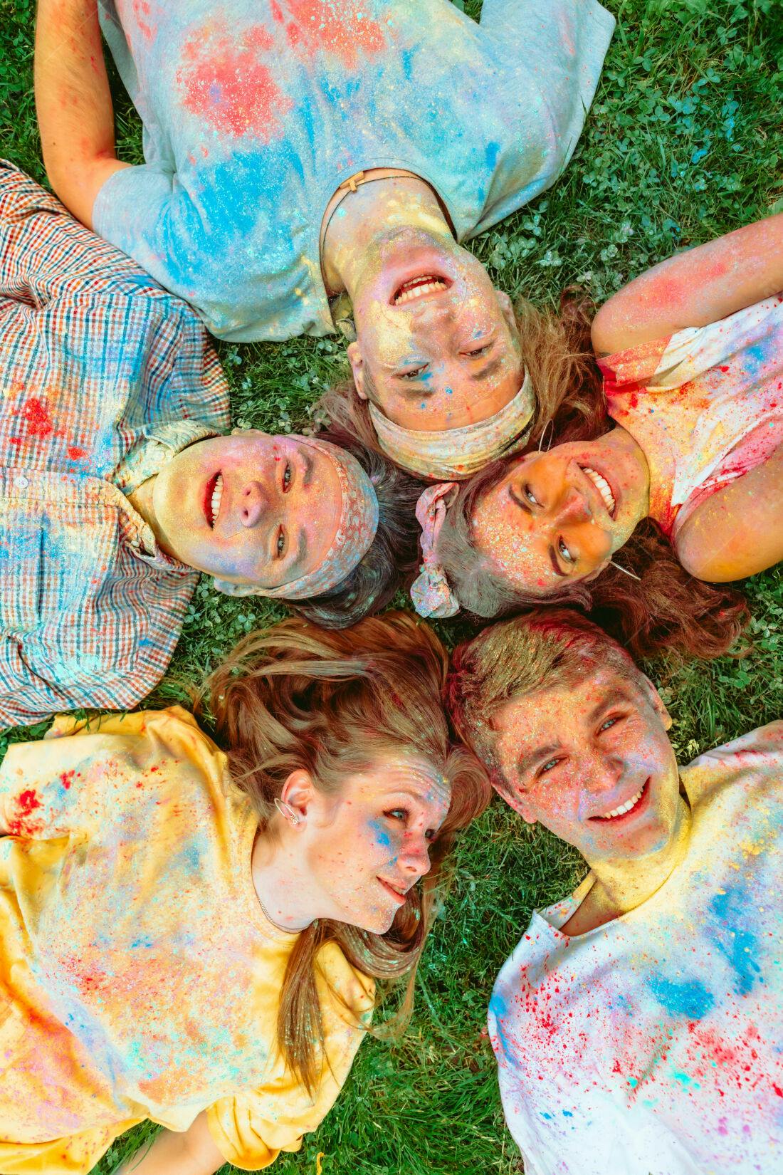 Amigos cobertos de pó colorido em gramado