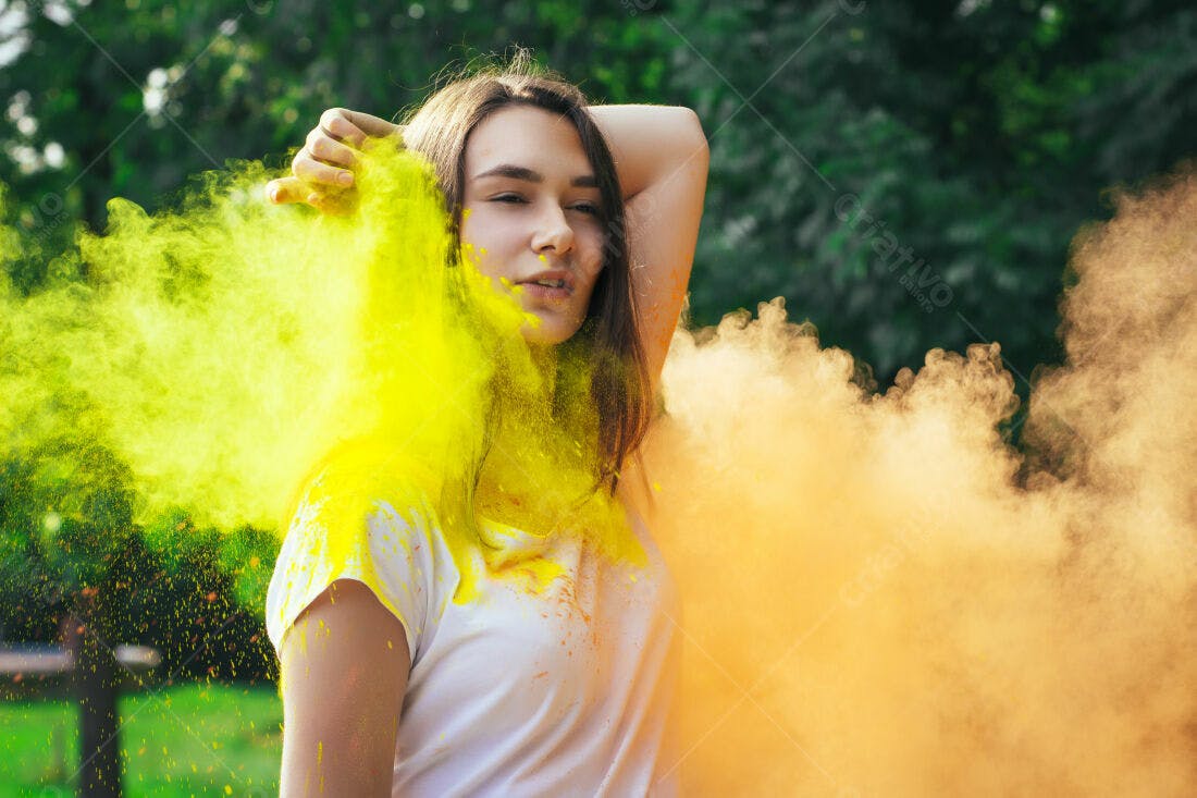 Mulher com pó colorido amarelo e laranja