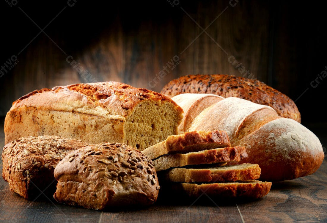 Pães artesanais variados sobre madeira escura